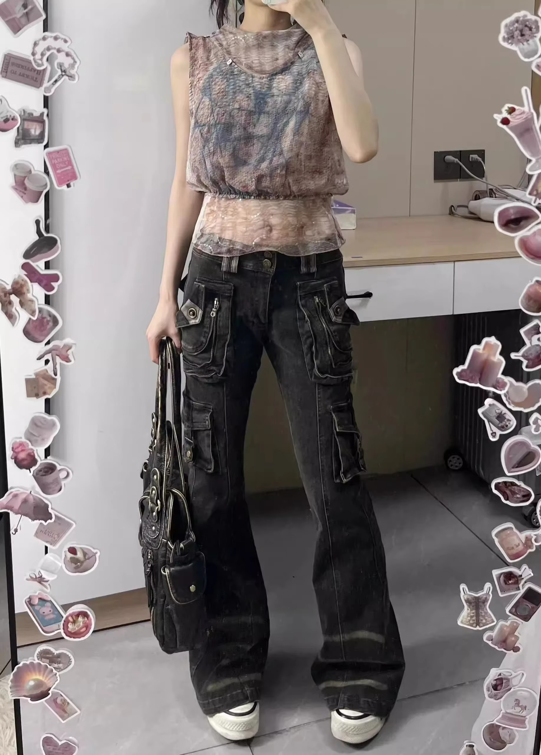 Person wearing a patterned top and dark jeans in a room with a desk and chair.